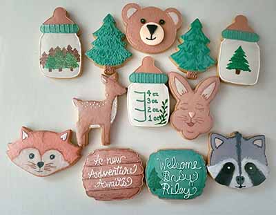 Baby shower cookie tray: Baby bottles, trees, bear, fox, racoon, deer and rabbit.