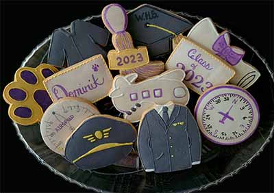 Graduation cookie tray: Pilot hat, and jacket, plane, gages, graduation gown, hat, tassle, and diploma.