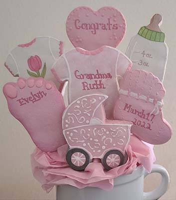 Baby cookie bouquet: Onesies, heart, bottle, foot, bootie, and baby carriage.