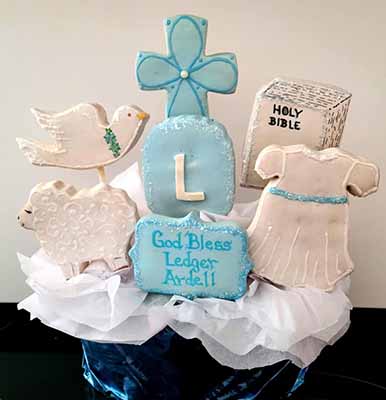 Baptism cookie bouquet: Bible, dove, cross, baptism gown, sheep, and monogram.