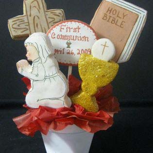 First communion cookie bouquet: Cross, Bible, girl kneeling, and chalice with first communion wafer.