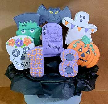 Halloween birthday cookie bouquet: Skull, bat, ghost, jack o'lantern, skull, Frankenstein, and numbers.