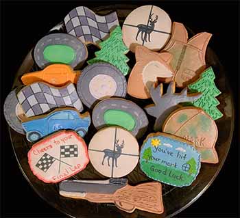 Retirement cookie tray: Deer, vest, scope, rifle, trees, race cars, tracks, and flag.