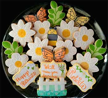 Retirement cookie tray: Flowers, butterflies, bee, branches and white picket fence.