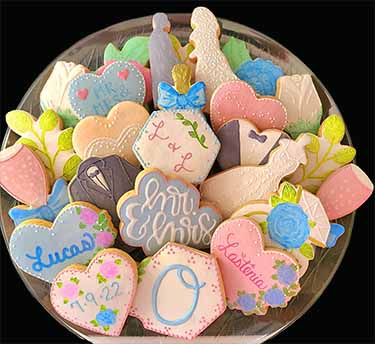 Wedding cookie platter: Bride, groom,hearts, flowers, jacket, dress and glasses of champagne.